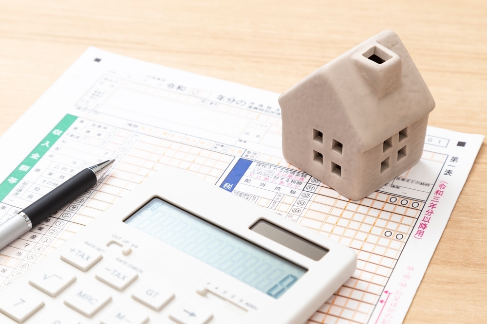 Tax return documents and a model house on a desk
