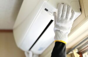 Hands with work gloves to install the air conditioner