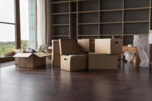 Heap of paper boxes for moving with household stuff stacked on floor in room
