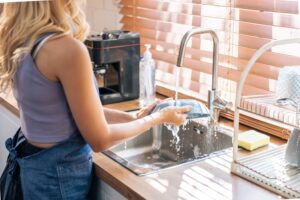 Close up hands of housewife washing dishes in at the kitchen sink
