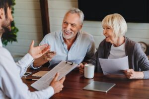Happy mature family couple of clients consulting legal expert