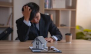 Man sitting at table, feeling sad and depressed about debts