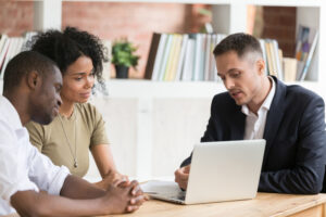 Realtor meeting with black millennial couple show house or apartment on laptop